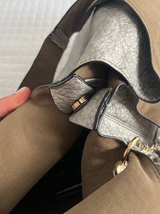 Bolso shopper plateado con colgante de flecos.