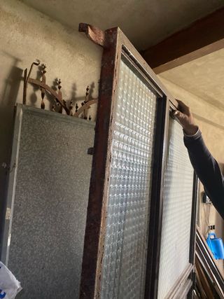 Puerta de hierro con cristal y reja