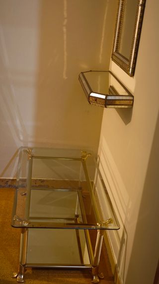 Mesa de centro de cristal y metal dorado.