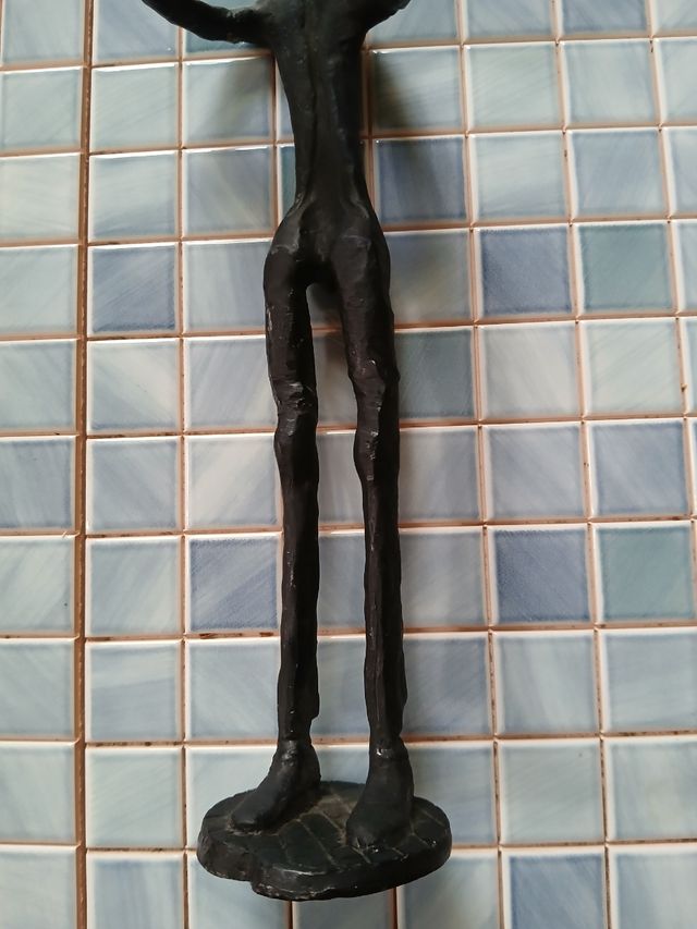 Escultura de metal de músico con trompeta