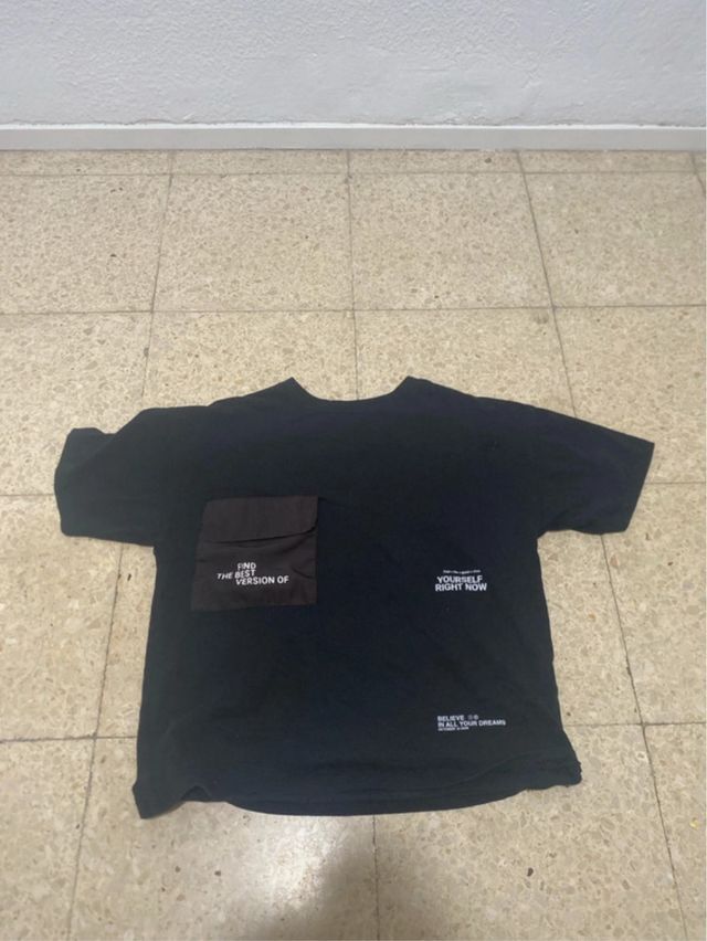 Camiseta Negra con Bolsillo y Mensaje.