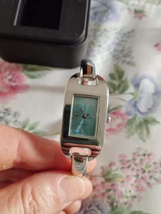 Reloj de pulsera plateado con esfera turquesa