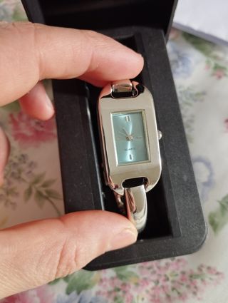 Reloj de pulsera plateado con esfera turquesa