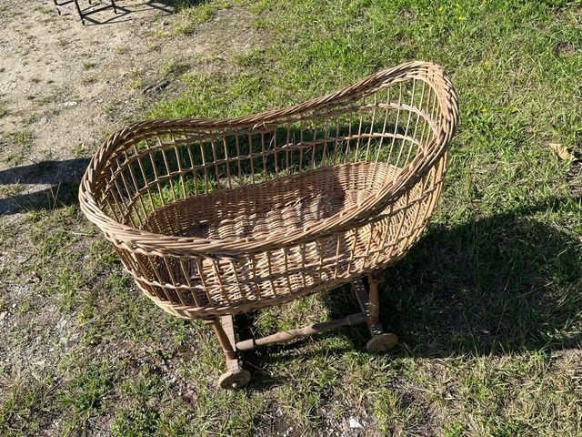 Moisés de mimbre antiguo con ruedas.
