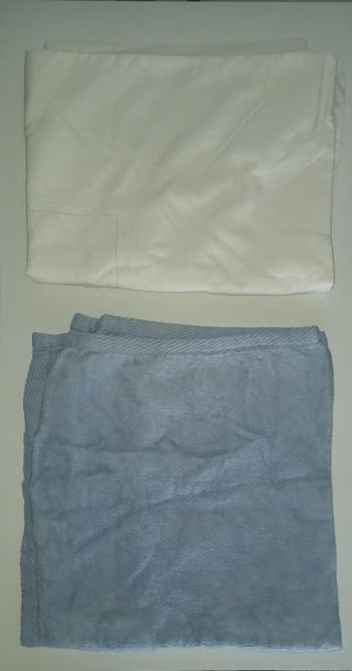 Cuna de bebé de madera con ruedas y mantas
