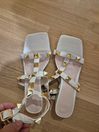 Sandalias blancas con tachuelas doradas