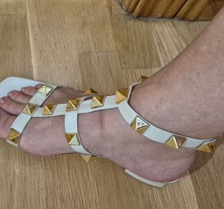 Sandalias blancas con tachuelas doradas