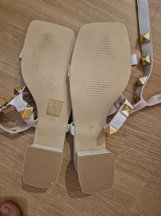 Sandalias blancas con tachuelas doradas