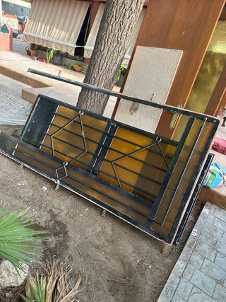 Puerta de entrada exterior con reja y cristal