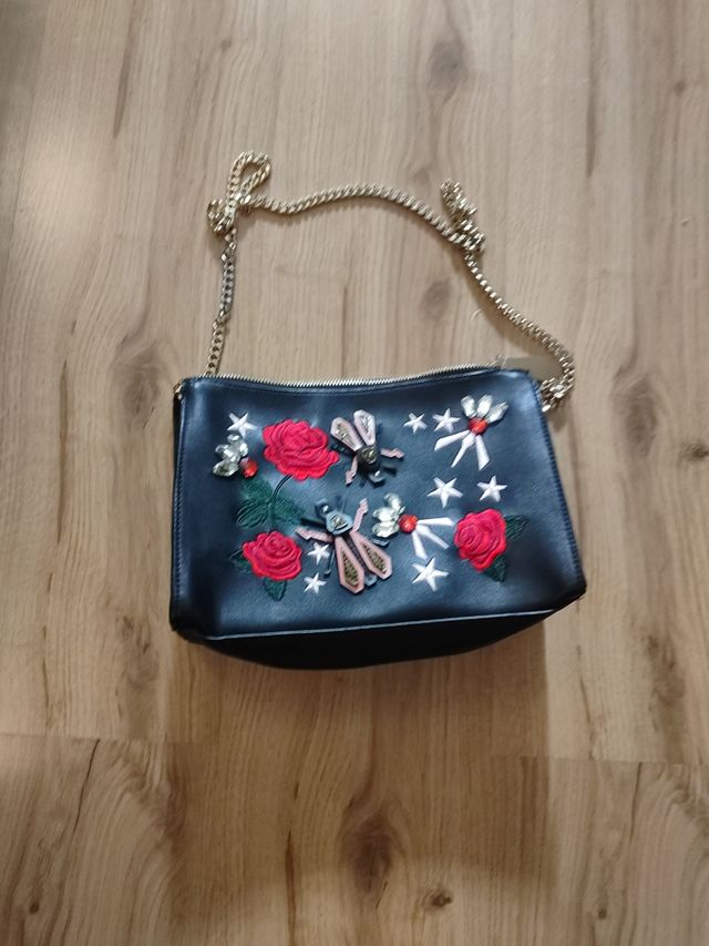 Bolso negro con bordado de flores y abejas