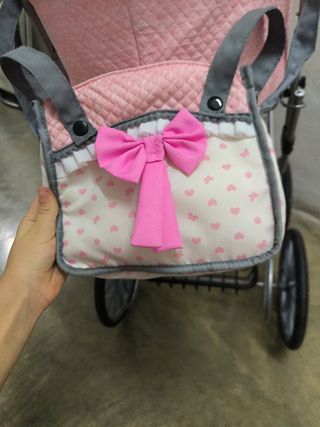 Carrito de bebé rosa con lazo