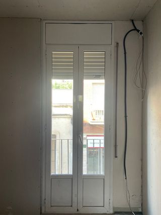 Puerta de balcón de aluminio y persiana blanca