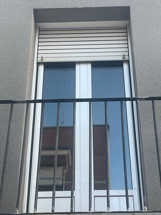 Puerta de balcón de aluminio y persiana blanca