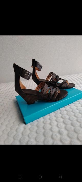 Sandalias marrón oscuro de cuña con tachuelas. 