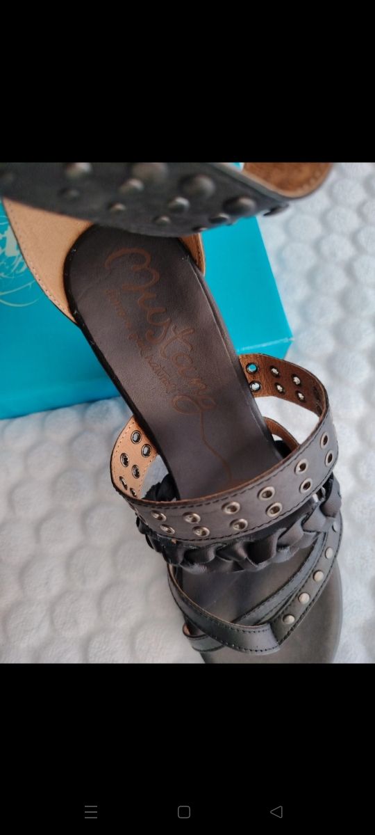 Sandalias marrón oscuro de cuña con tachuelas.