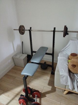 Banco de musculación con barra y pesas