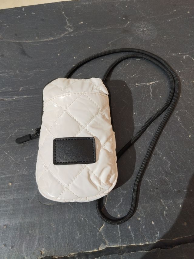 Borsa imbottita bianca con tracolla nera.