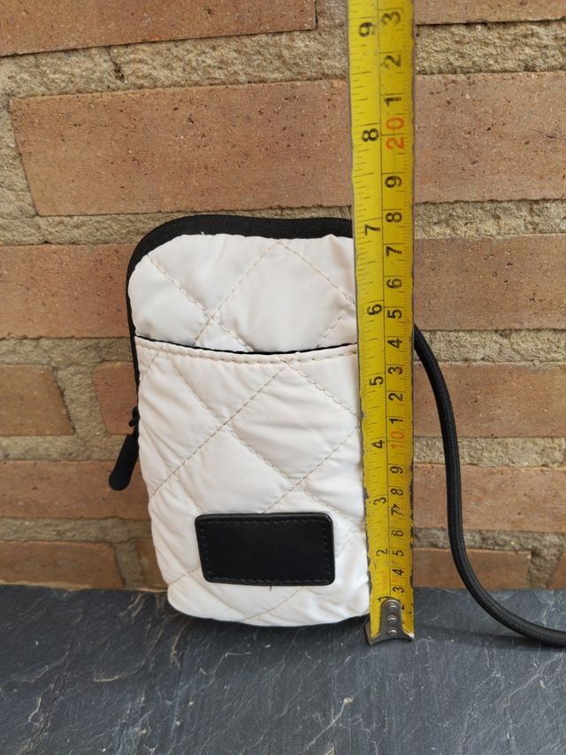 Borsa imbottita bianca con tracolla nera.