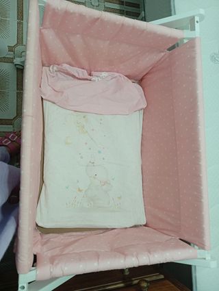 Cuna de bebé rosa con estampado de lunares