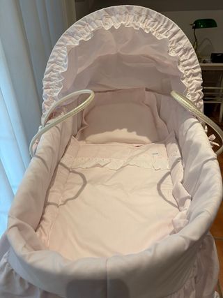 Cuna de bebé rosa con capota y ruedas