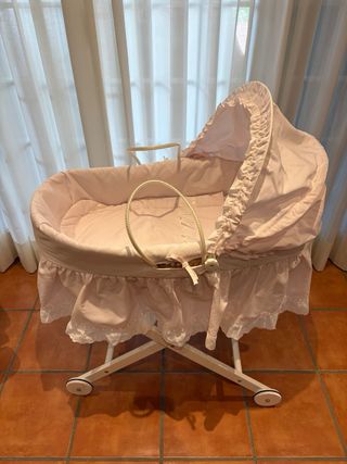 Cuna de bebé rosa con capota y ruedas