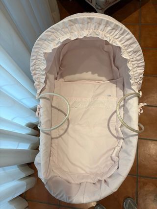 Cuna de bebé rosa con capota y ruedas