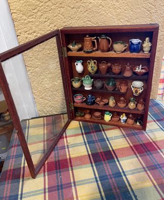 Vitrina con jarrones pequeños de barro
