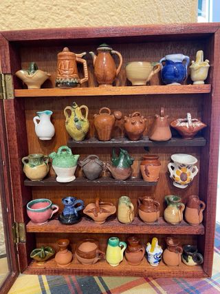 Vitrina con jarrones pequeños de barro