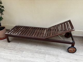 Tumbona de madera con ruedas, con cojines.