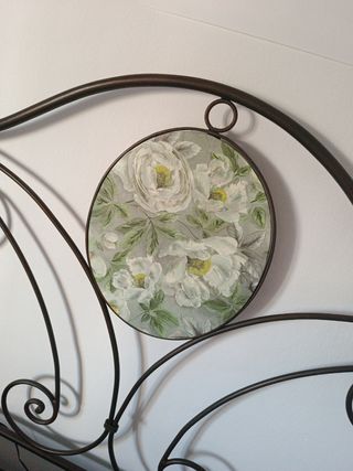 Cabecero de cama de forja con detalles dorados.