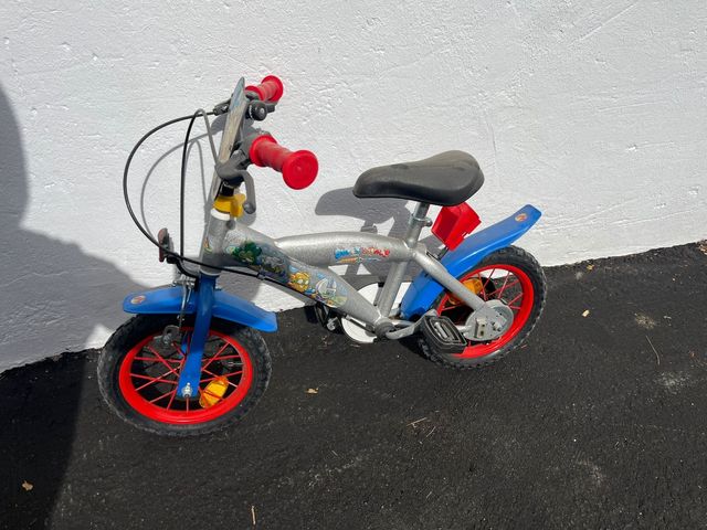 Bicicleta infantil plateada con ruedas rojas