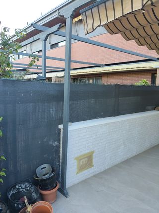 Pérgola extensible beige con rayas marrones.