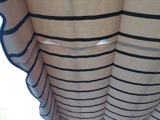 Pérgola extensible beige con rayas marrones.