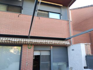 Pérgola extensible beige con rayas marrones.