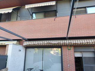 Pérgola extensible beige con rayas marrones.