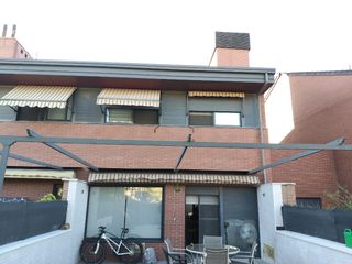 Pérgola extensible beige con rayas marrones.