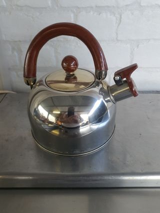 Tetera de metal con mango de madera