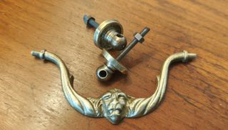 Tirador antiguo de bronce con cara de león.