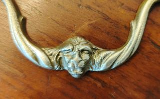 Tirador antiguo de bronce con cara de león.