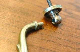 Tirador antiguo de bronce con cara de león.