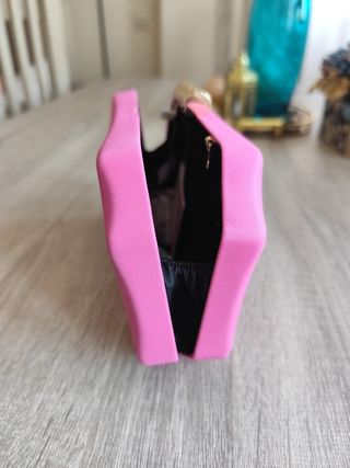 Bolso de mano rosa con detalle dorado