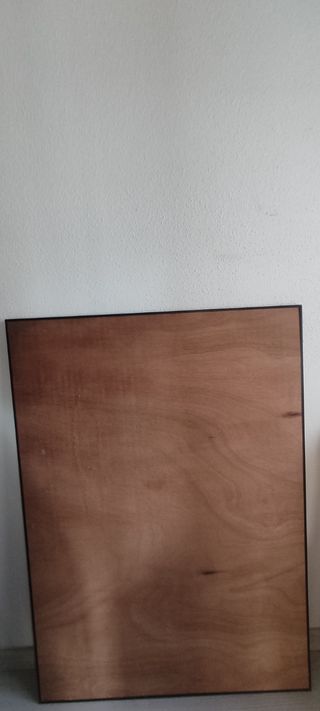 Tablero de madera con marco y plástico.
