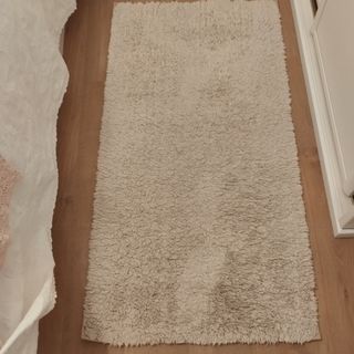 Alfombra lavable beige de tela.
