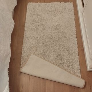Alfombra lavable beige de tela.