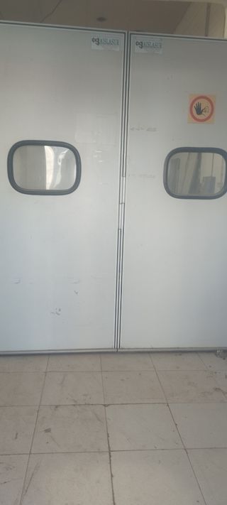 Puerta corredera industrial con ventana
