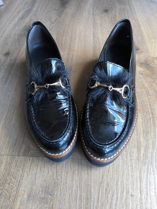 Mocasines negros con pelo y estribo dorado