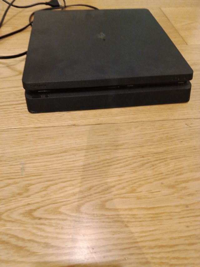 PS4 negra con un  mando