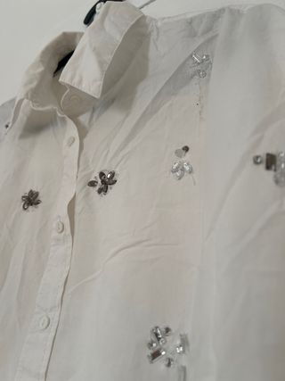 Blusa blanca con adornos plateados