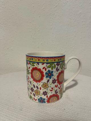 Taza de cerámica multicolor con flores.