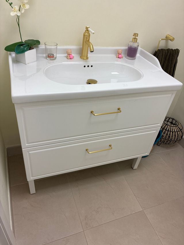 Mueble de baño con lavabo y grifería dorada
